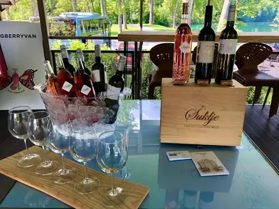 a bunch of wine bottles and glasses on a table at BREZA mobile house BIG BERRY in Metlika