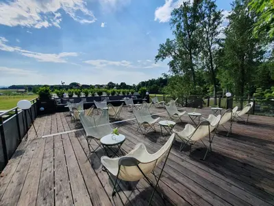 a bunch of chairs and tables on a wooden deck at BREZA mobile house BIG BERRY in Metlika