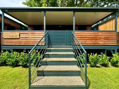a staircase leading up to a house with a bench at BREZA mobile house BIG BERRY in Metlika