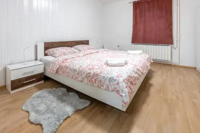 a bedroom with a bed with a red and white comforter at Apartma Lozar in Ajdovščina