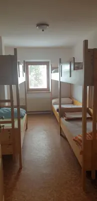 a room with two bunk beds and a window at Črnuški dom na Mali planini in Krivčevo