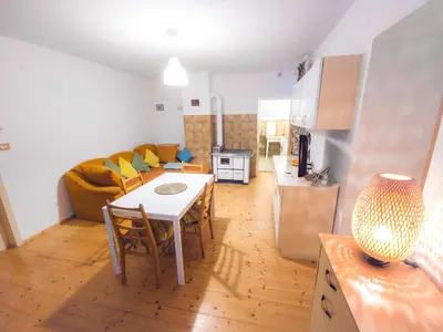 a kitchen and living room with a table and a couch at Apartma Florent in Bovec