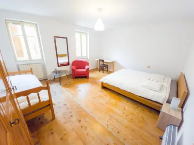 a bedroom with a bed and a red chair at Apartma Florent in Bovec