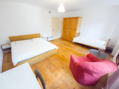 a bedroom with a bed and a couch and a chair at Apartma Florent in Bovec