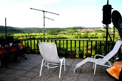 two chairs and a table on a balcony with a view at Apartment Šefic in Planina