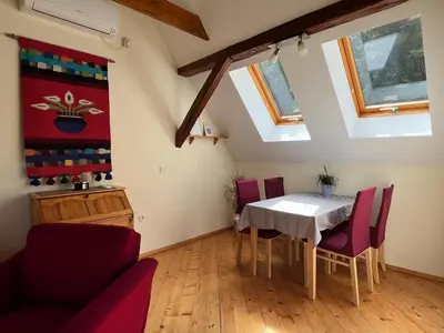 a dining room with a table and red chairs at Apartment Šefic in Planina