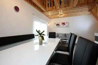 a dining room with a white table and black chairs at Apartments Klemenčič in Bohinj