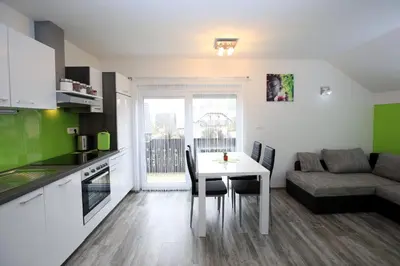 a kitchen and living room with a table and a couch at Apartments Klemenčič in Bohinj