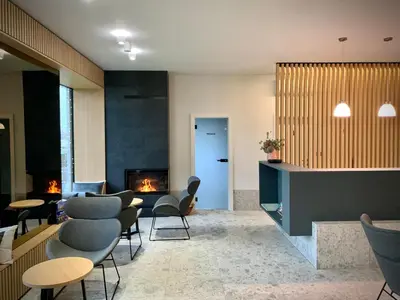 a lobby with chairs and a fireplace in a room at Stara lipa Tašner kitchen & P & garage - self check-in in Maribor