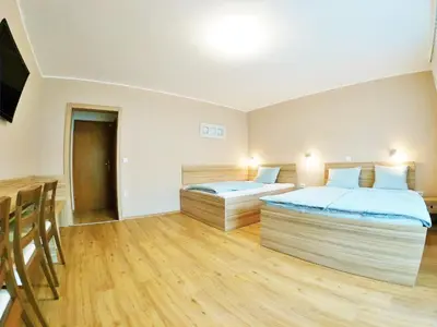 a bedroom with two beds and a table and chairs at Stara lipa Tašner kitchen & P & garage - self check-in in Maribor