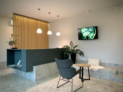 a lobby with a chair and a tv on a wall at Stara lipa Tašner kitchen & P & garage - self check-in in Maribor