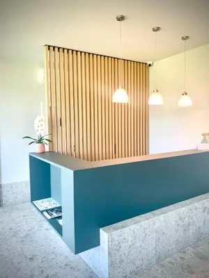 a reception desk in a lobby with two pendant lights at Stara lipa Tašner kitchen & P & garage - self check-in in Maribor