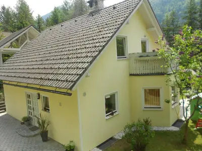 a yellow house with a gray roof at Apartments Irena in Kranjska Gora