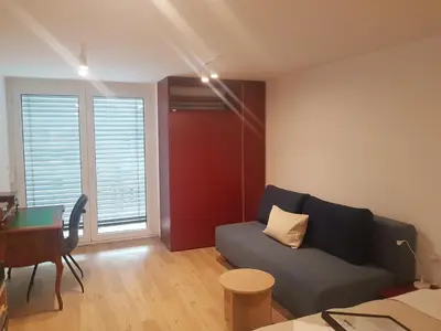 a living room with a couch and a table and a desk at Jojo apartment in Ljubljana