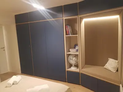 a bedroom with blue cabinets and a bed with white sheets at Jojo apartment in Ljubljana