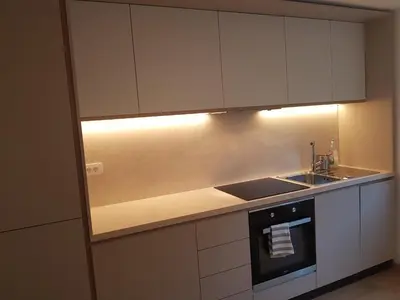 a kitchen with white cabinets and a sink and a stove at Jojo apartment in Ljubljana