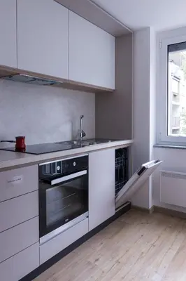 a kitchen with white cabinets and a sink and a stove at Jojo apartment in Ljubljana