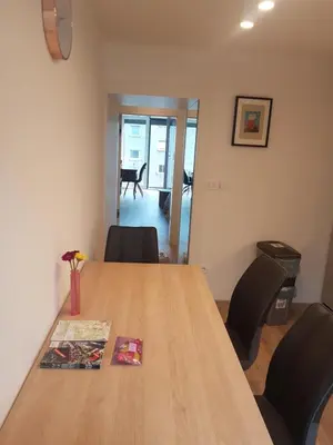 a wooden table in an office with chairs around it at Jojo apartment in Ljubljana
