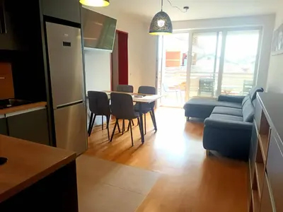 a kitchen and living room with a table and a blue couch at Apartment Hakuna Matata in Moravske Toplice
