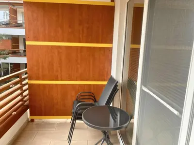 a small balcony with two chairs and a table at Apartment Hakuna Matata in Moravske Toplice