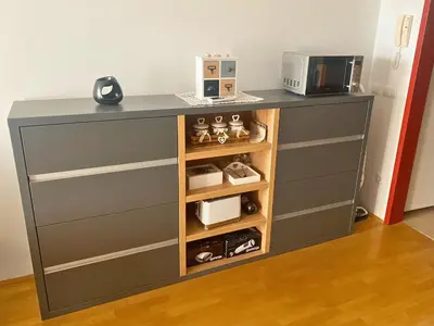 a gray dresser with a microwave on top of it at Apartment Hakuna Matata in Moravske Toplice