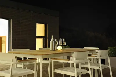 a dining room with a wooden table and white chairs at Oranda Village in Rogaška Slatina