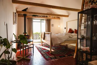 a bedroom with a bed and a large window at MÓD in Lendava