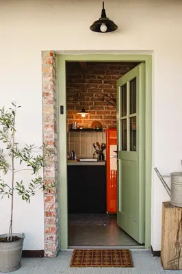 a green door leading into a kitchen with a counter at MÓD in Lendava