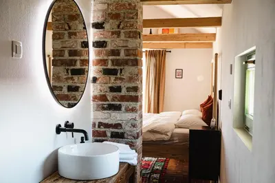 a bathroom with a white sink and a brick wall at MÓD in Lendava