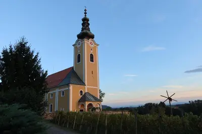 a church with a clock tower on a hill at Rezidenca Sv. Peter in Malečnik