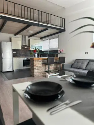a kitchen and living room with a table with plates on it at Apartment Štucin in Vipava