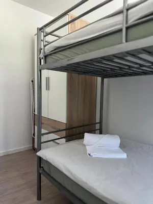 a bedroom with a bunk bed with white sheets at Apartment Štucin in Vipava