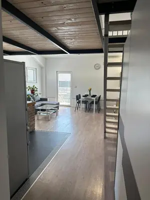 a living room and dining room with a spiral staircase at Apartment Štucin in Vipava