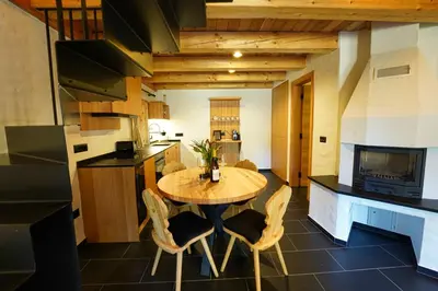 a kitchen with a wooden table and chairs at Alpine Retreat Apartments Šurc in Rateče