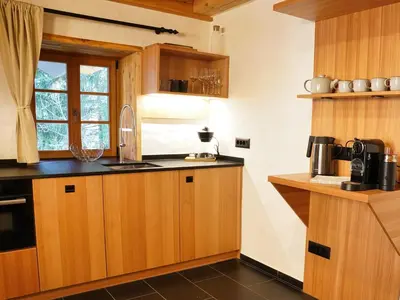 a kitchen with wooden cabinets and a window at Alpine Retreat Apartments Šurc in Rateče