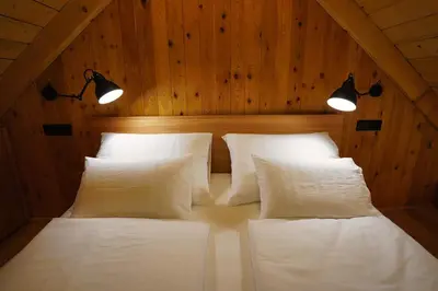 a bedroom with two white pillows and two lights at Alpine Retreat Apartments Šurc in Rateče