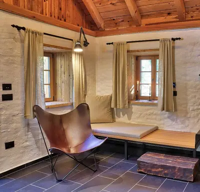 a room with a couch and a chair and windows at Alpine Retreat Apartments Šurc in Rateče