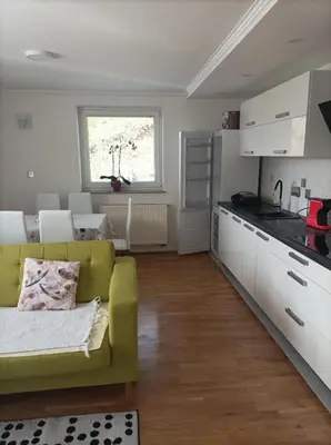 a living room with a yellow couch and a kitchen at RELAX in Kamnik