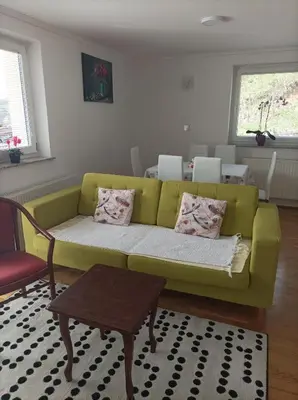 a living room with a green couch and a table at RELAX in Kamnik