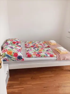 a bed with two sheets and two towels on it at RELAX in Kamnik