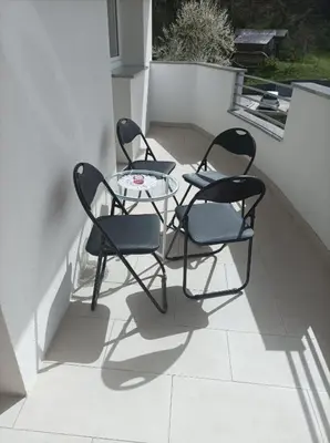 three chairs and a glass table on a patio at RELAX in Kamnik