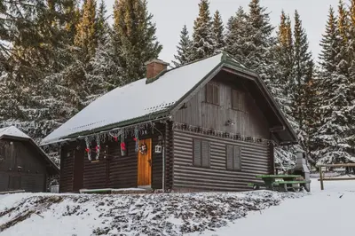 a log cabin with snow on the roof at Apartment Zarja - Trije Kralji in Zgornja Ložnica