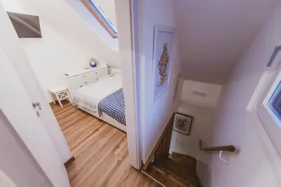 a small bedroom with a bed and a stairway at Apartment Zarja - Trije Kralji in Zgornja Ložnica