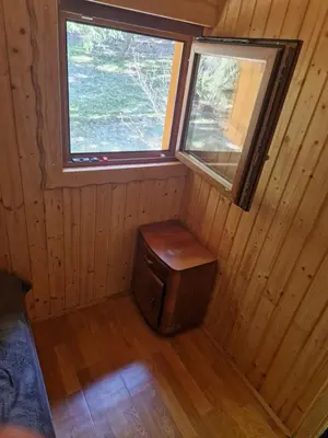 an empty cabin with a window and a wooden floor at Koča v gozdu, Forest house near Bled in Bled