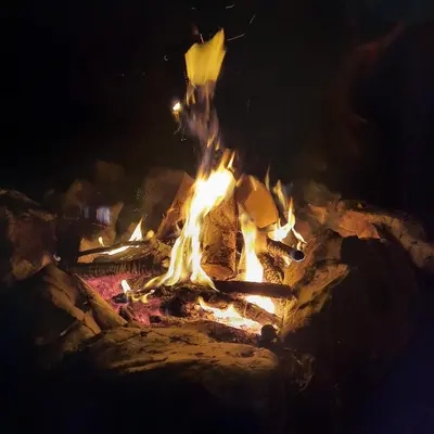 a fire is burning in a fire pit at night at Koča v gozdu, Forest house near Bled in Bled