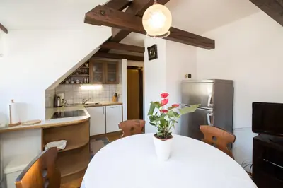a kitchen with a table with a vase of flowers on it at Apartmaji Hodnik Stara Fužina in Bohinj