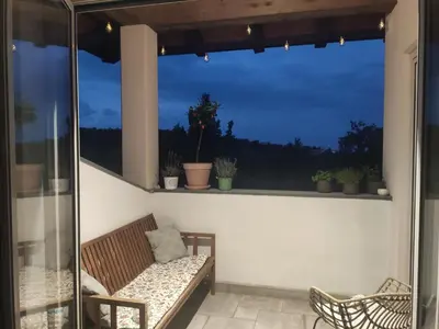 a balcony with a couch and a window with plants at Apartma Lavanda in Kojsko