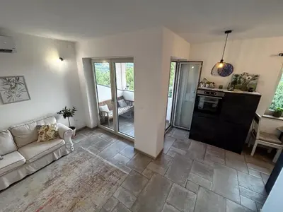 a living room with a couch and a kitchen at Apartma Lavanda in Kojsko