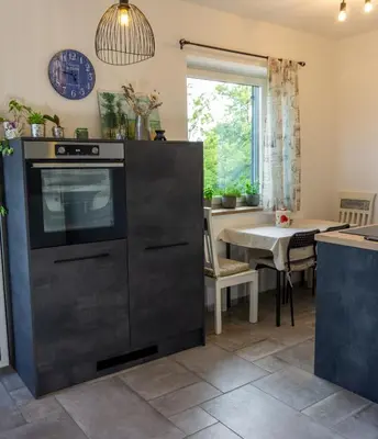 a kitchen with a black oven and a table at Apartma Lavanda in Kojsko