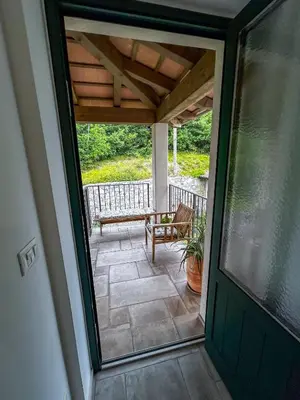 an open door to a porch with a bench at Apartma Lavanda in Kojsko